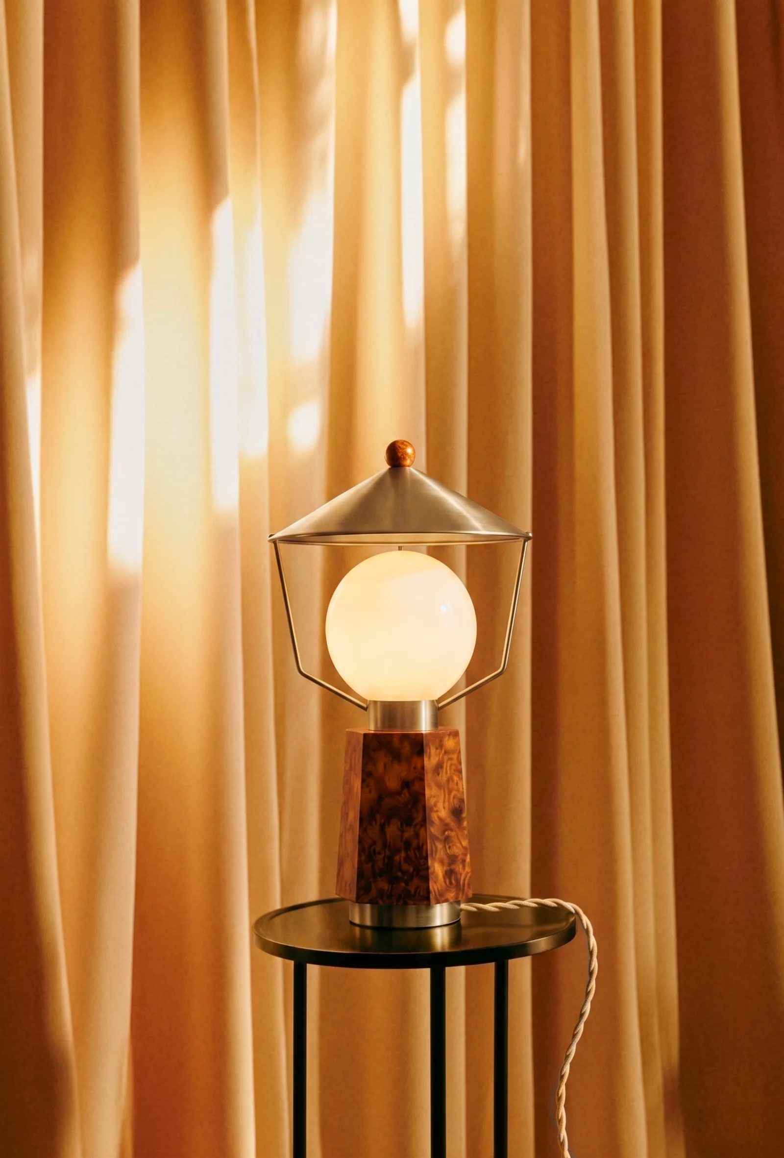 La lampe à poser : chapeau de laiton, cage filaire, globe de verre opalin sur socle en ronce de noyer